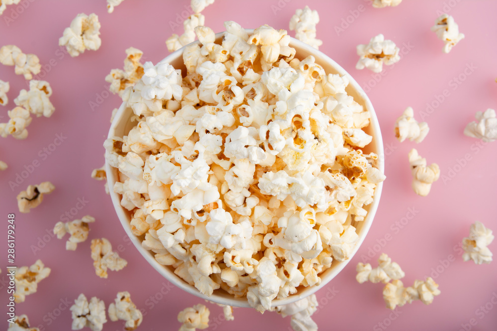 Warm popcorn viewed from above on pink background. Top view. Enterteinment concept Warm popcorn viewed from above on pink background. Top view. Enterteinment concept