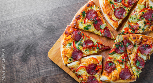 Pepperoni Pizza with Mozzarella cheese, salami, pepper. Spices and Fresh basil. Italian pizza on wooden table background
