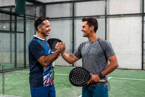 two padel players shaking hands after win a padel match
