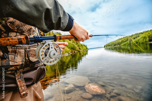 Bild auf Leinwand Fisherman using rod fly fishing in mountain river