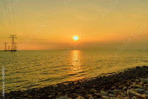 a golden sunset on the sea, photographed at a coastal avenue in shenzhen, china © Jingye