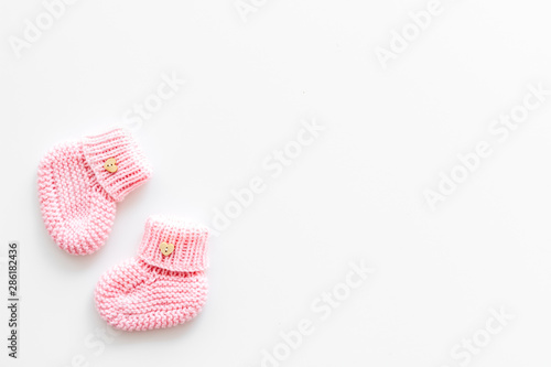 Cute baby booties for girl on white background top view copyspace