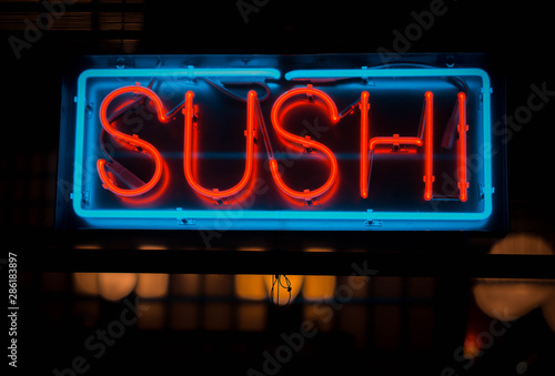 neon sushi sign outside of a restaurant