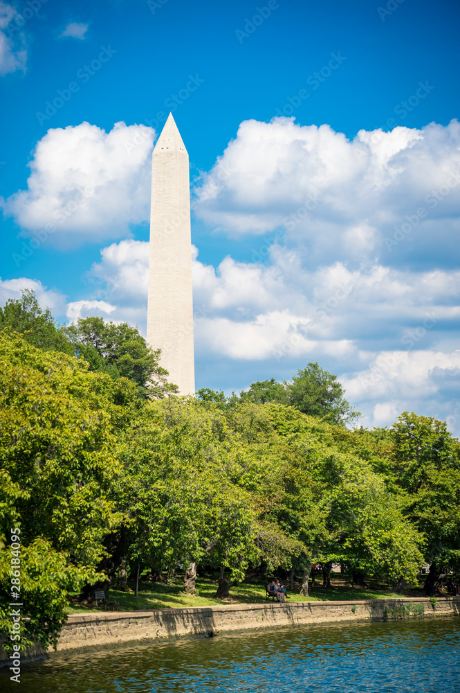 Scenic summer view of the Washington Monument with summer greenery on the Mall with bright summer clouds in Washington DC, USA