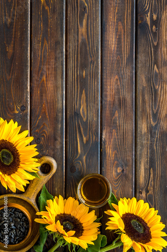 Frame of sunflowers  oil and seeds on wooden background top view mockup