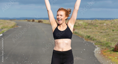 Pretty woman with red hair exercising outside © Mat Hayward