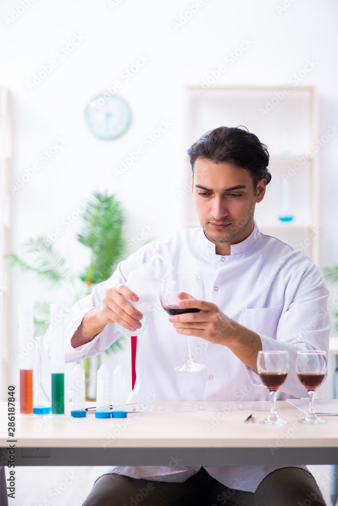 Male chemist examining wine samples at lab Male chemist examining wine samples at lab