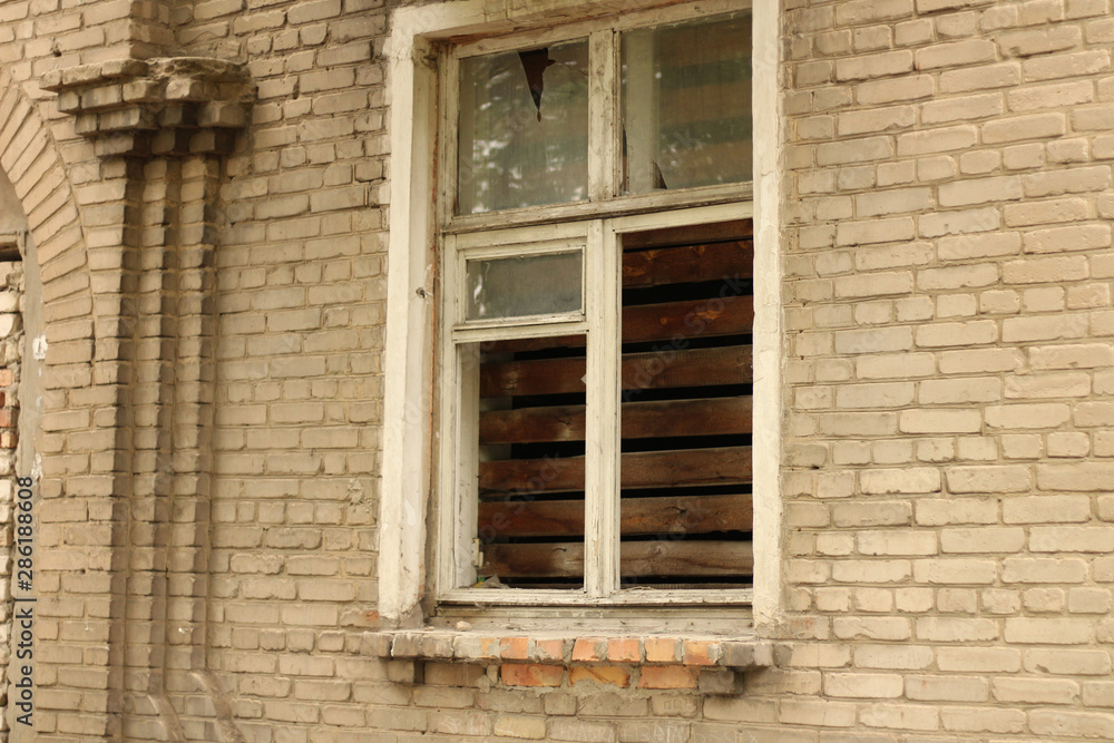 smashed a shot of an old brick building planked window at the Donbass in Ukraine