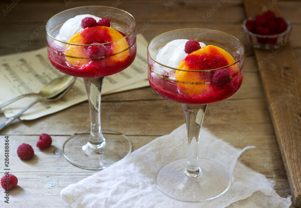 Ice cream, peach and raspberry sauce dessert dedicated to Australian opera singer Melba. Rustic style.