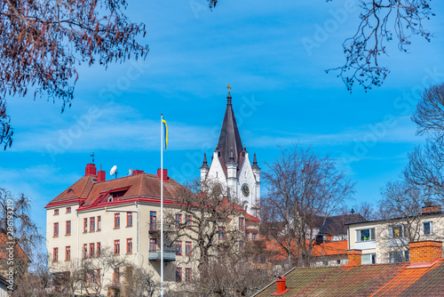 White church in Nora viewed behind timber houses, Sweden photo