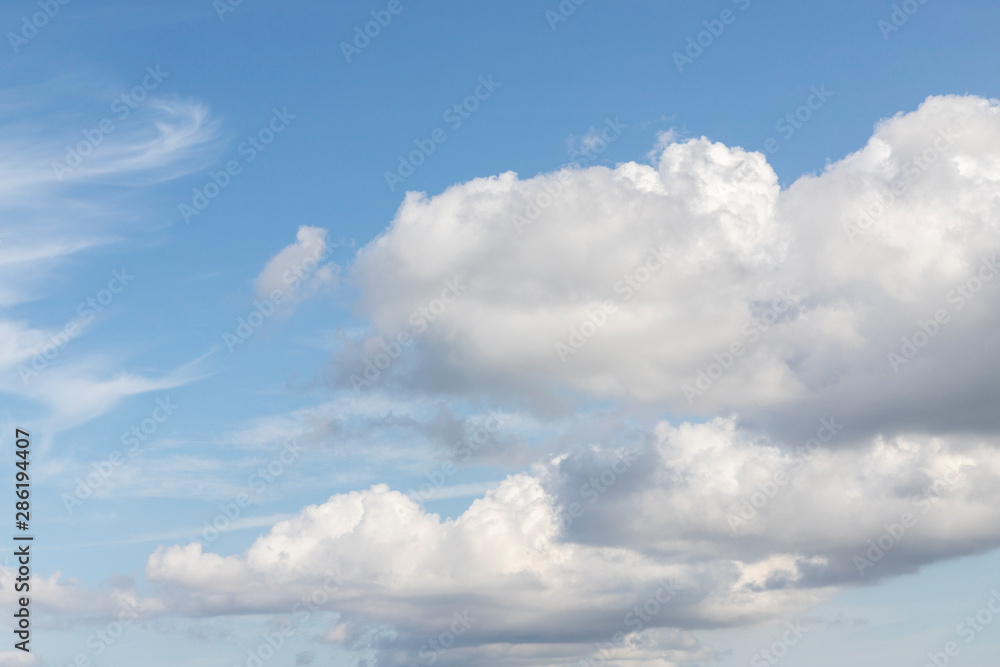 Obraz premium Blue sky and clouds. Cumulus clouds on a blue sky. Cloudy summer, spring or winter weather. Background with free space and empty place.