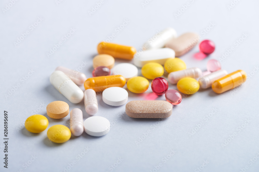 Vitamins and supplements on bright paper background. Concept for a healthy dietary supplementation. Close up. Copy space. Vitamins and supplements on bright paper background. Concept for a healthy dietary supplementation. Close up. Copy space.