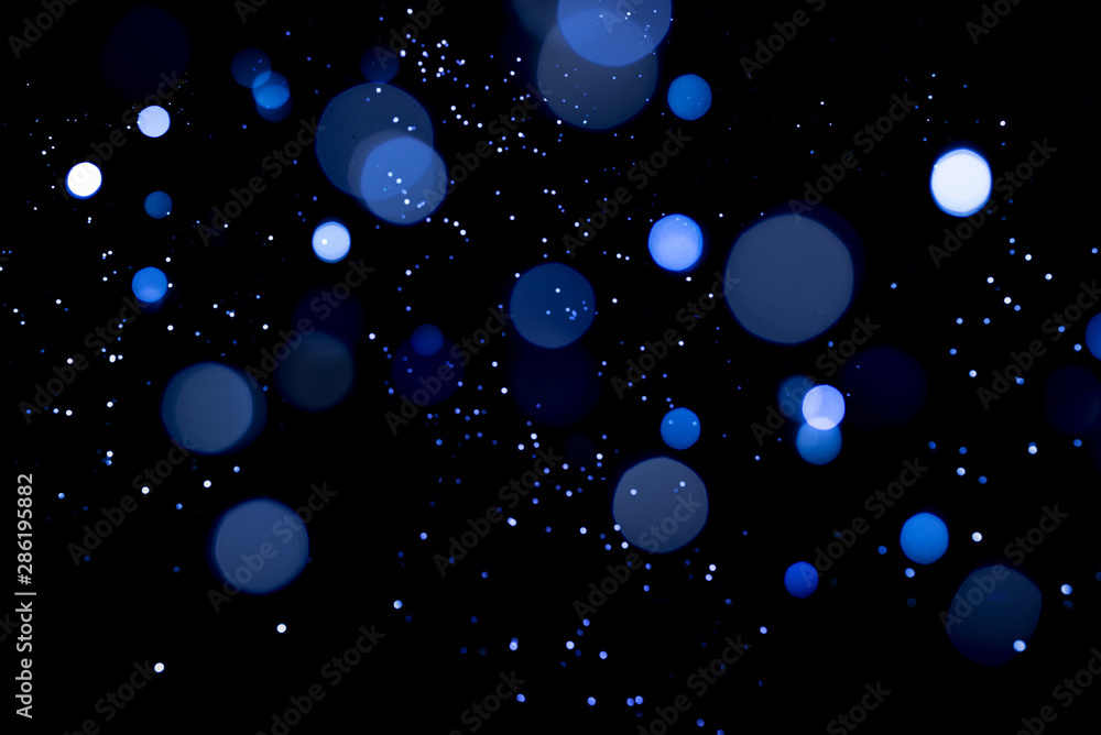 Blue abstract bokeh on dark background. Holiday concept