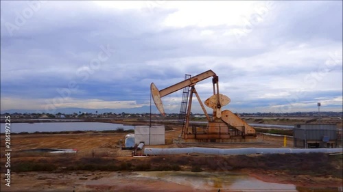 Oil derricks pumping with cloudy sky