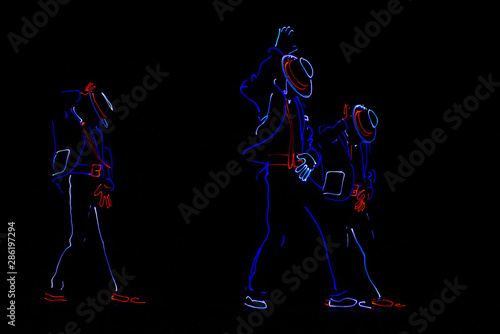 Fototapeta Dancers in suits with LED lamps.