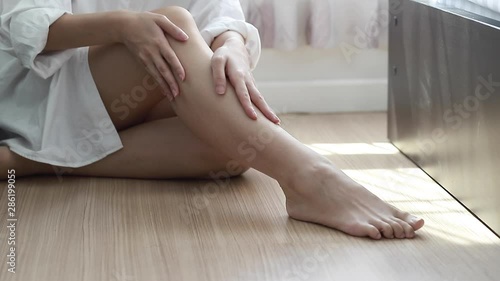 Sexy woman is stroking her legs for applying cream.