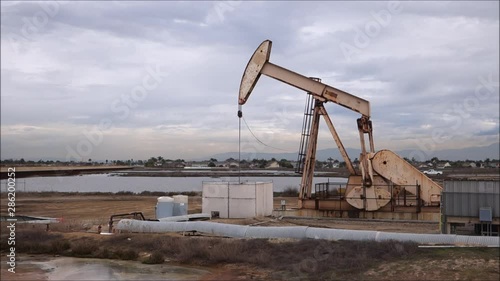Oil derricks pumping with cloudy sky