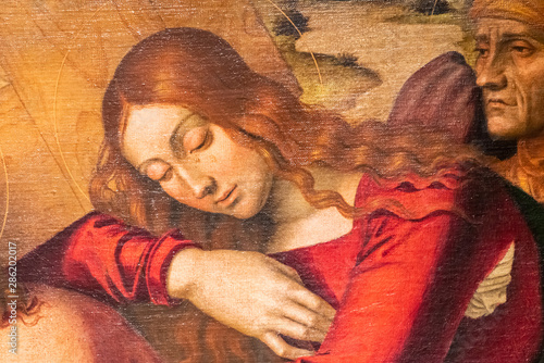 Detail of medieval painting showing beautiful long haired girl weeping