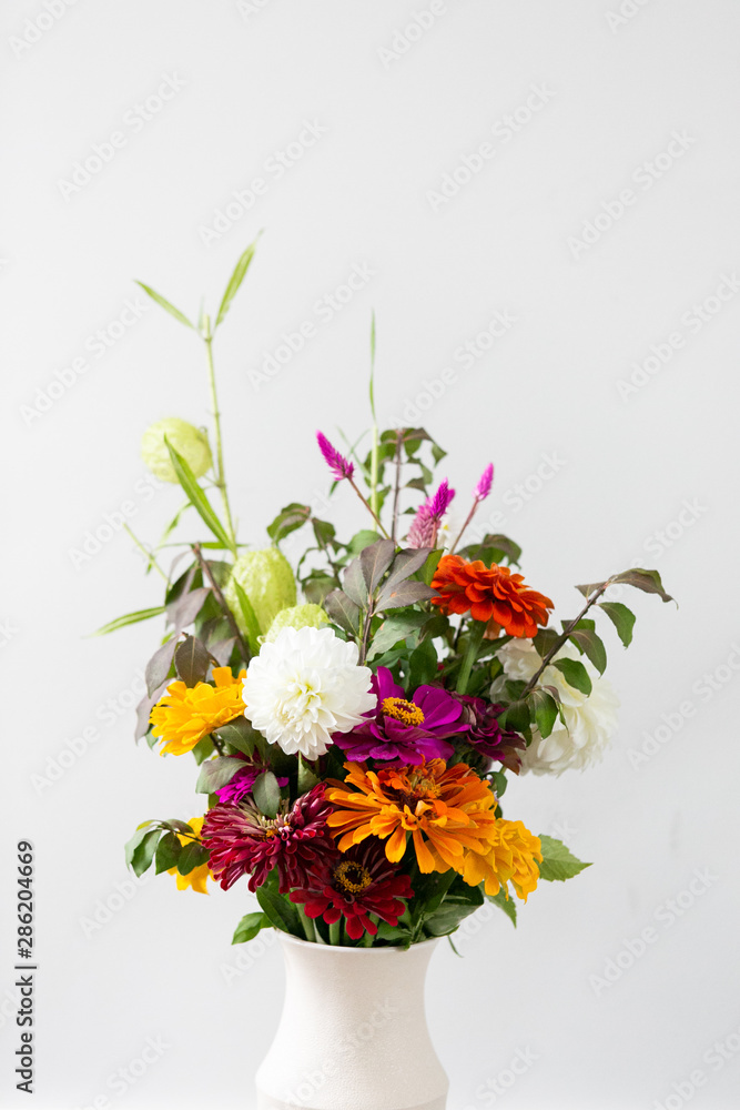Colorful orange, white, purple flower bouquet in vase, white background, copy space, organic summer garden bouquet 