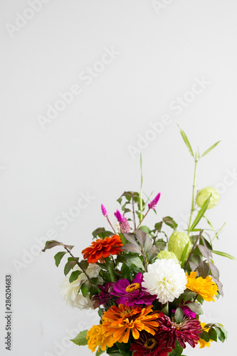 Colorful orange  white  purple flower bouquet in vase  white background  copy space  organic summer garden bouquet 