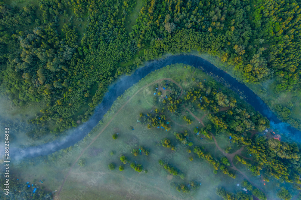 Aerial view of the forest, field and river covered with layers of thick morning fog Aerial view of the forest, field and river covered with layers of thick morning fog