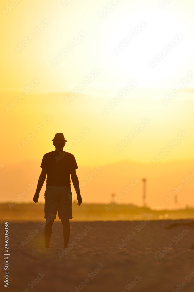 Silhouette of a man meditating at sunset.