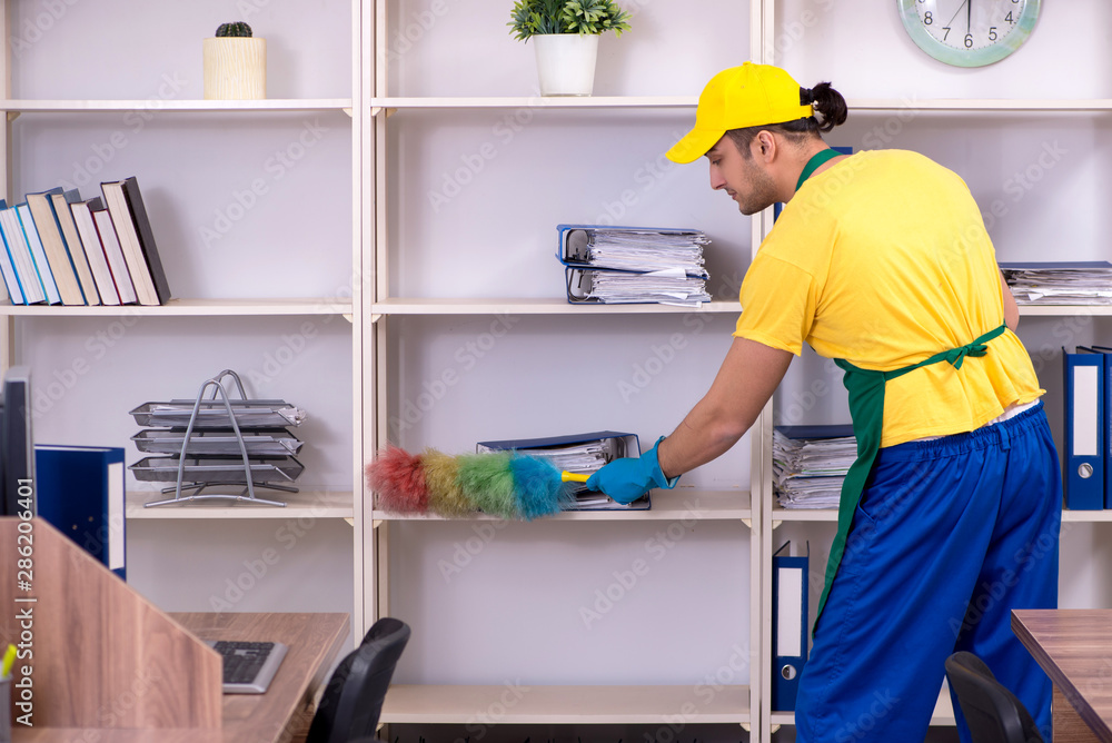 Young male contractor cleaning the office Young male contractor cleaning the office