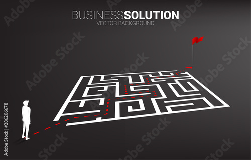 Silhouette of businessman with route path to exit the maze to flag. Business concept for problem solving and solution strategy