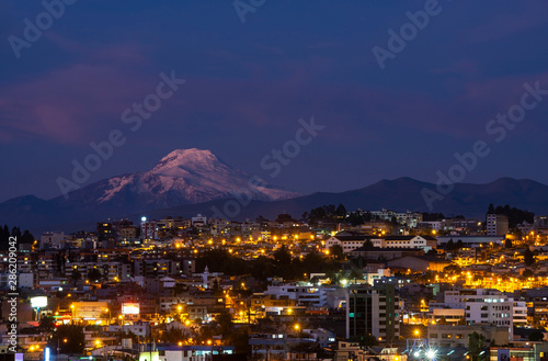 Cityscape of Quito at night with the impressive Cayambe volcano, Andes mountains, Ecuador, South America. © SL-Photography