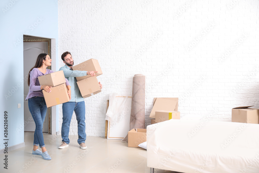 Young couple with belongings after moving into new house Young couple with belongings after moving into new house