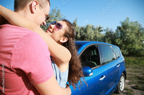 Happy young couple near car...