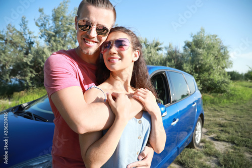 Happy young couple near car...