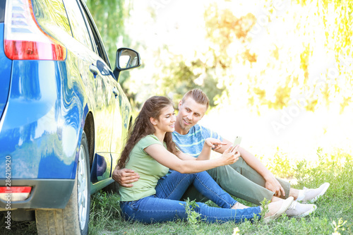 Happy young couple near car...