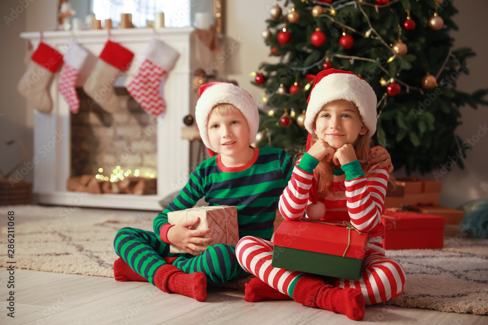 Cute little children with Christmas gifts at home Cute little children with Christmas gifts at home