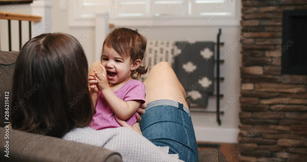 Mother and baby girl playing together on the couch. Cinematic 4K footage. Mother and baby girl playing together on the couch. Cinematic 4K footage.