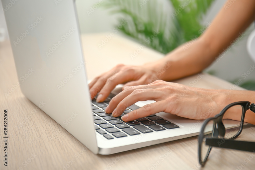 Woman working on laptop in office, closeup Woman working on laptop in office, closeup