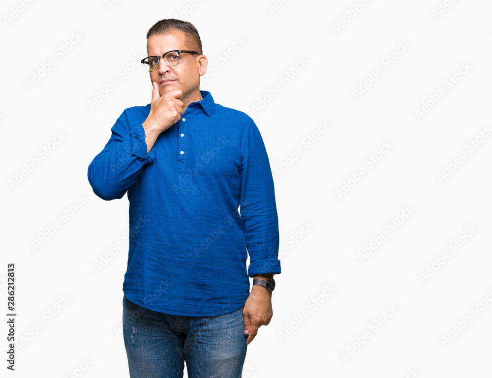 Middle age arab man wearing glasses over isolated background looking confident at the camera with smile with crossed arms and hand raised on chin. Thinking positive. Middle age arab man wearing glasses over isolated background looking confident at the camera with smile with crossed arms and hand raised on chin. Thinking positive.