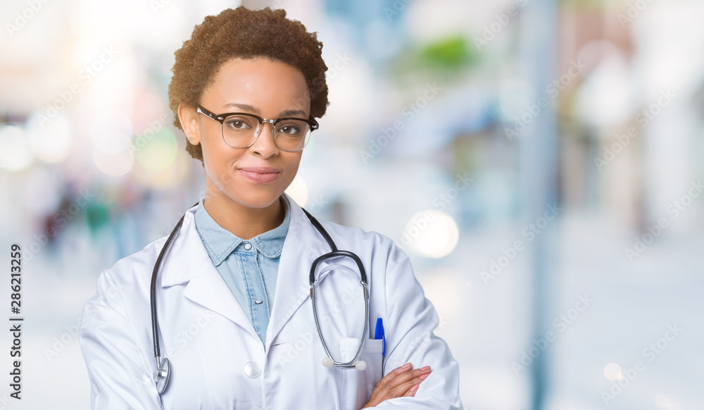Young african american doctor woman wearing medical coat over isolated background happy face smiling with crossed arms looking at the camera. Positive person. Young african american doctor woman wearing medical coat over isolated background happy face smiling with crossed arms looking at the camera. Positive person.