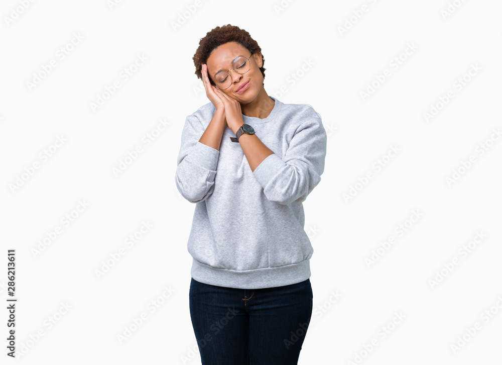 Young beautiful african american woman wearing glasses over isolated background sleeping tired dreaming and posing with hands together while smiling with closed eyes. Young beautiful african american woman wearing glasses over isolated background sleeping tired dreaming and posing with hands together while smiling with closed eyes.