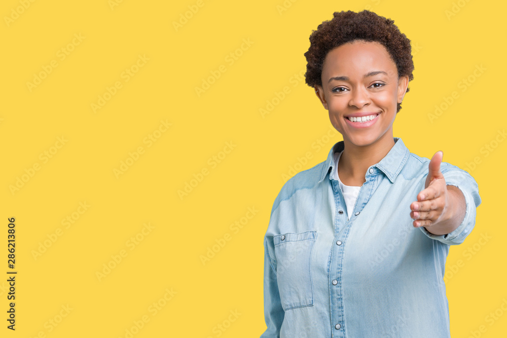 Young beautiful african american woman over isolated background smiling friendly offering handshake as greeting and welcoming. Successful business. Young beautiful african american woman over isolated background smiling friendly offering handshake as greeting and welcoming. Successful business.