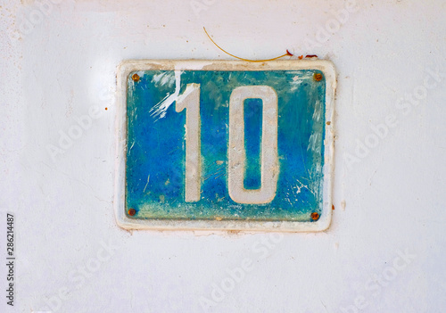 Number 10 / ten, rustic plate blue number on the wall.