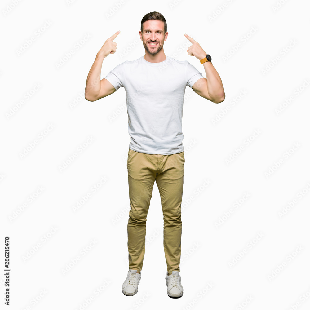 Handsome man wearing casual white t-shirt Smiling pointing to head with both hands finger, great idea or thought, good memory Handsome man wearing casual white t-shirt Smiling pointing to head with both hands finger, great idea or thought, good memory