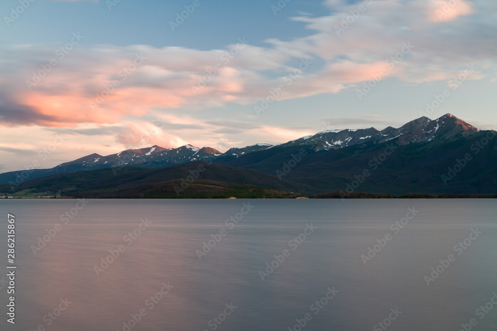 Sunset lights up the clouds over Dillon Reservoir and the Tenmile Mountain Range in Dillon, Colorado.