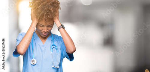 Fotografie Young african american doctor woman over isolated background suffering from headache desperate and stressed because pain and migraine