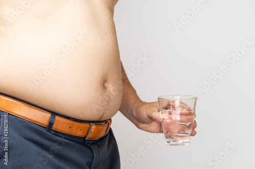 belly of a Japanese fat man holding a cup of water