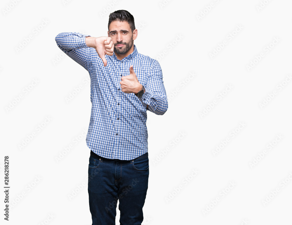 Young handsome man over isolated background Doing thumbs up and down, disagreement and agreement expression. Crazy conflict Young handsome man over isolated background Doing thumbs up and down, disagreement and agreement expression. Crazy conflict
