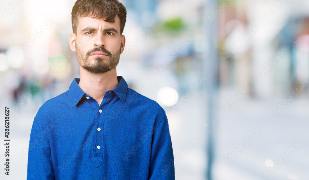 Young handsome man over isolated background skeptic and nervous, frowning upset because of problem. Negative person. Young handsome man over isolated background skeptic and nervous, frowning upset because of problem. Negative person.