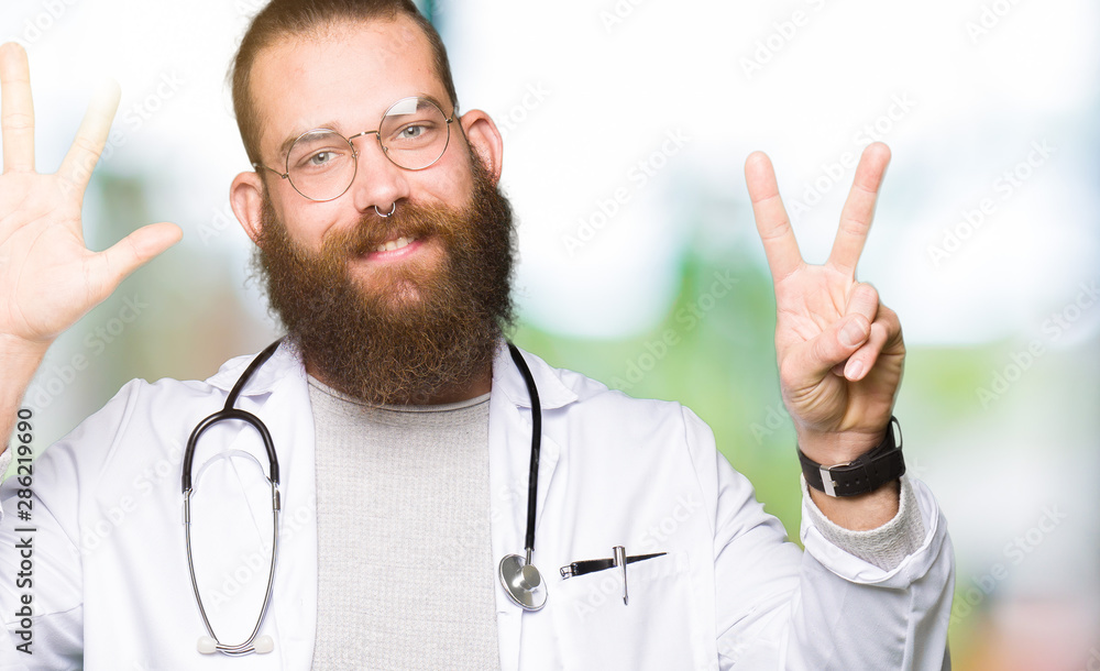 Young blond doctor man with beard wearing medical coat showing and pointing up with fingers number seven while smiling confident and happy. Young blond doctor man with beard wearing medical coat showing and pointing up with fingers number seven while smiling confident and happy.