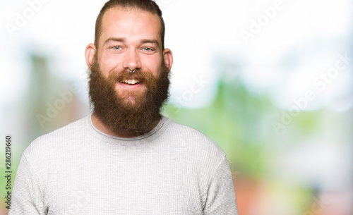 Young blond man wearing casual sweater with a happy and cool smile on face. Lucky person. © Krakenimages.com