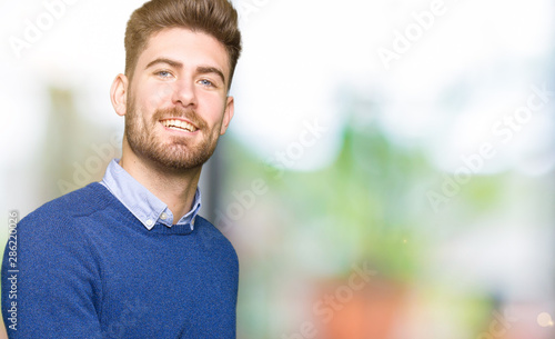 Young handsome bussines man Inviting to enter smiling natural with open hand